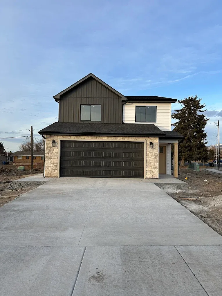 Two-story custom home with stone wainscot, evergreens